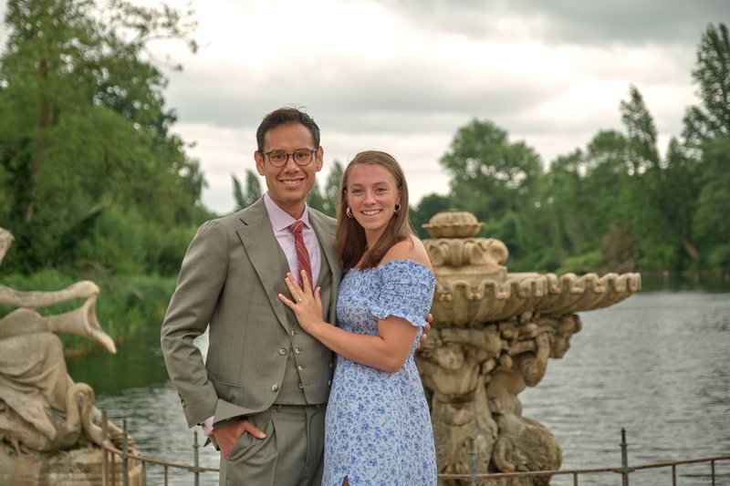 Lucy and Victor smiling beside the stone fountain, London