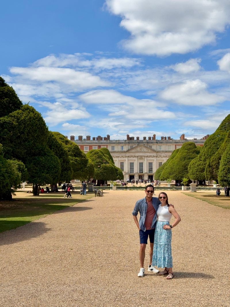 Lucy and Victor on a garden path in front of a palace